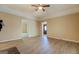 Spacious living room featuring light wood-look flooring, ceiling fan, and open access to other rooms at 34 Ivy St, Porterdale, GA 30014