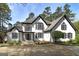 Stately home showcasing white stucco, dark trim, bay windows, and a meticulously landscaped yard with mature trees at 3320 Lost Valley Dr, Jonesboro, GA 30236