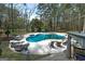 A kidney-shaped pool and spa are surrounded by mature trees and ample patio space with seating at 3320 Lost Valley Dr, Jonesboro, GA 30236