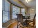 Breakfast nook with a modern glass table, gray upholstered chairs, and large bay windows at 106 Kirkland Rd, Covington, GA 30016