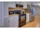 A view of the kitchen with stainless steel appliances, white cabinets and wood-look flooring at 106 Kirkland Rd, Covington, GA 30016