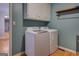 Well-equipped laundry area with a washer, dryer, and cabinet for storage at 106 Kirkland Rd, Covington, GA 30016
