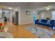 Open living area showcasing hardwood floors, a blue sofa, and seamless access to the kitchen and dining areas at 106 Kirkland Rd, Covington, GA 30016