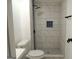 Modern bathroom features tiled shower with gray accent and contrasting fixtures at 851 Bridgewater Ct, Stone Mountain, GA 30088