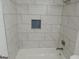Shower featuring white marble-look tiling, a built-in niche, and a modern shower head at 851 Bridgewater Ct, Stone Mountain, GA 30088