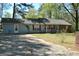 Cozy one-story home with light blue vinyl siding, brick accents, red shutters, and ample parking space at 121 Juniper Dr, Mcdonough, GA 30253