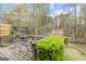 Wooden backyard deck with seating, offering a relaxing outdoor space surrounded by mature trees and lush greenery at 2733 Newtons Crest Cir, Snellville, GA 30078