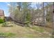 Tranquil backyard featuring a sloped lawn with mature trees and a wooden staircase leading to the upper level at 2733 Newtons Crest Cir, Snellville, GA 30078
