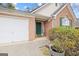 Charming brick home featuring a green front door, white garage door, and landscaped bushes at 2733 Newtons Crest Cir, Snellville, GA 30078