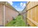 Narrow side yard showcasing the fence line and the exterior of the brick home at 2733 Newtons Crest Cir, Snellville, GA 30078