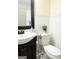 Bathroom featuring a toilet and sink with decorative accents and a mirror at 6544 Bussell Way, Riverdale, GA 30274