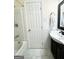Bathroom featuring a shower with bath, white tiled walls, dark wood vanity and white sink at 6544 Bussell Way, Riverdale, GA 30274