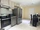 Spacious kitchen with stainless steel appliances, tile flooring and adjacent dining area at 6544 Bussell Way, Riverdale, GA 30274