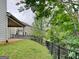 A grassy backyard features a black metal fence and mature landscaping at 461 Best Friends Turn Aly, Mcdonough, GA 30252