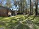 Scenic backyard view featuring a well-maintained lawn, mature trees, and the rear of the brick home at 4063 Windsor Castle Way, Decatur, GA 30034