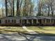 Charming single story red brick home with black shutters, white walkway, and covered front porch at 4063 Windsor Castle Way, Decatur, GA 30034
