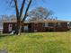 Exterior backyard view with brick home and overgrown lawn at 4487 Berkshire Rd, Forest Park, GA 30297