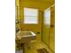 A retro-style bathroom features yellow tiling, a glass shower door, and an updated toilet and sink at 4487 Berkshire Rd, Forest Park, GA 30297