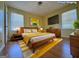 Staged bedroom with bed, yellow accents, and natural light from two windows at 4487 Berkshire Rd, Forest Park, GA 30297