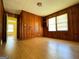 An empty room with wood paneling and hardwood floors, ready to be personalized as a bedroom at 4487 Berkshire Rd, Forest Park, GA 30297