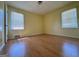 A yellow-painted bedroom featuring hardwood laminate flooring and two large windows at 4487 Berkshire Rd, Forest Park, GA 30297