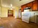 A kitchen featuring wood cabinets, laminate floors and white appliances at 4487 Berkshire Rd, Forest Park, GA 30297