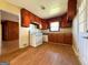 Traditional kitchen featuring wood cabinets, laminate floors, and white appliances at 4487 Berkshire Rd, Forest Park, GA 30297