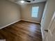 Bedroom features wood-look floors, a ceiling fan, and natural light from the window at 260 Countryside Ln, Covington, GA 30016