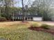 Well-kept front yard featuring green grass, shrubs, and a driveway leading to a two-car garage at 260 Countryside Ln, Covington, GA 30016