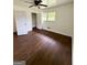 Cozy bedroom featuring hardwood floors, ample natural light from a window, and closet space at 1322 S Hicks Cir Nw, Conyers, GA 30012