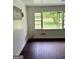 Bright living room features rich wood flooring, a large window, and crisp white trim at 1322 S Hicks Cir Nw, Conyers, GA 30012