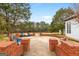 Brick patio with outdoor seating, trees, and white exterior at 2615 Hampton Locust Grove Rd, Locust Grove, GA 30248