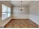 Dining room featuring hardwood floors, large window, and traditional chandelier at 483 Castle Top Ln, Lawrenceville, GA 30045