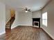 Bright living room features hardwood floors, fireplace, ceiling fan, and staircase at 483 Castle Top Ln, Lawrenceville, GA 30045