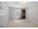 Simple bedroom with neutral carpet, a window, light colored walls, and a dark bookshelf at 5217 Hollyhock Rd, Douglasville, GA 30135
