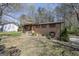 Traditional brick home showcasing a well-maintained front lawn and mature trees with a side house in the background at 5217 Hollyhock Rd, Douglasville, GA 30135