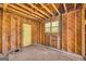 An unfinished room with exposed wood paneling, window, and a yellow door showcases renovation potential at 2255 Beecher Sw Rd, Atlanta, GA 30311