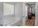 Bathroom with a large tub, natural light, and view into the primary bedroom at 1293 Coan Dr, Locust Grove, GA 30248