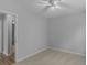 Neutral bedroom with light carpet, ceiling fan, and freshly painted gray walls. Open door to bathroom at 1293 Coan Dr, Locust Grove, GA 30248