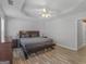 Comfortable primary bedroom features wood-look floors, tray ceiling, ceiling fan, and natural light at 1293 Coan Dr, Locust Grove, GA 30248
