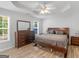 Comfortable primary bedroom features wood-look floors, tray ceiling, ceiling fan, and natural light at 1293 Coan Dr, Locust Grove, GA 30248