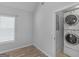 Laundry room features stacked washer and dryer, neutral walls and flooring at 1293 Coan Dr, Locust Grove, GA 30248