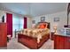 A bedroom with a plush bed, bright window, and dark wood furniture provides a calm and inviting space at 1058 Hartwell Rd, Locust Grove, GA 30248
