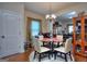 Dining room with a glass top table, cream colored chairs, hard wood floors and a chandelier at 1058 Hartwell Rd, Locust Grove, GA 30248