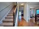 Inviting entryway with hardwood floors, staircase, and view into the kitchen and dining room at 1058 Hartwell Rd, Locust Grove, GA 30248