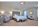 Spacious main bedroom with a tray ceiling, sitting area, and carpeted floors at 1058 Hartwell Rd, Locust Grove, GA 30248