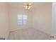 Neutral bedroom boasts a ceiling fan, carpeted floor, and a bright window with window blinds at 325 Autumn Glen Cir, Fayetteville, GA 30215