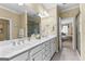 Bright bathroom featuring double sinks, tile floors, and shower with a view to the adjacent bedroom at 365 Grand Teton Cir, Fayetteville, GA 30215