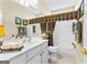 Bright bathroom featuring vanity, toilet, and shower-tub combo with patterned curtain at 365 Grand Teton Cir, Fayetteville, GA 30215
