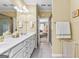 Bright bathroom with double sinks and an open doorway featuring views of a shower and the bedroom beyond at 365 Grand Teton Cir, Fayetteville, GA 30215
